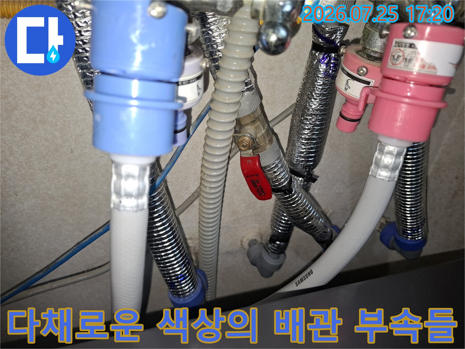 적색 핸들 밸브와 분홍색 파란색 커넥터가 조합된 복잡한 배관 구조