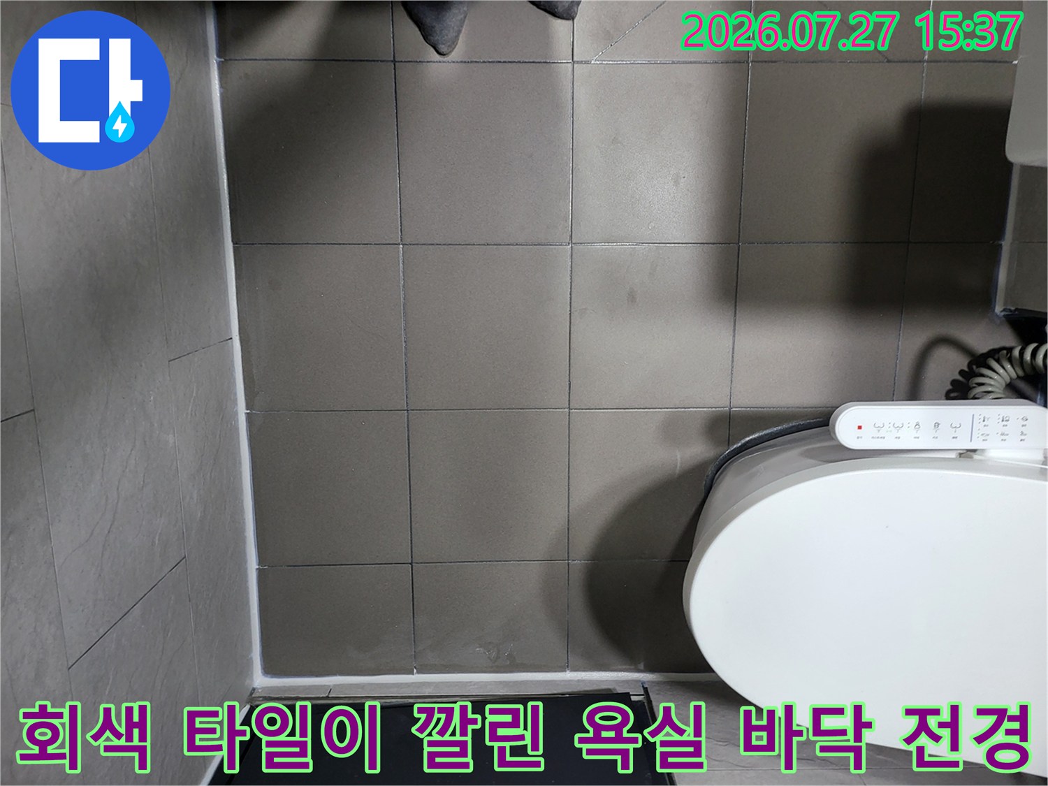 회색빛 사각 타일 마감과 흰색 비데가 배치된 화장실-상단뷰