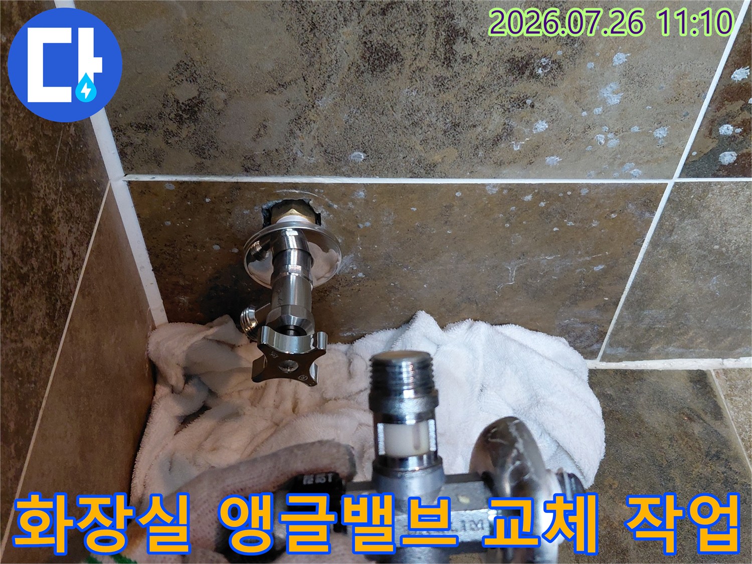 화장실 벽면에 설치된 노후한 앵글밸브를 새 제품으로 교체하는 장면