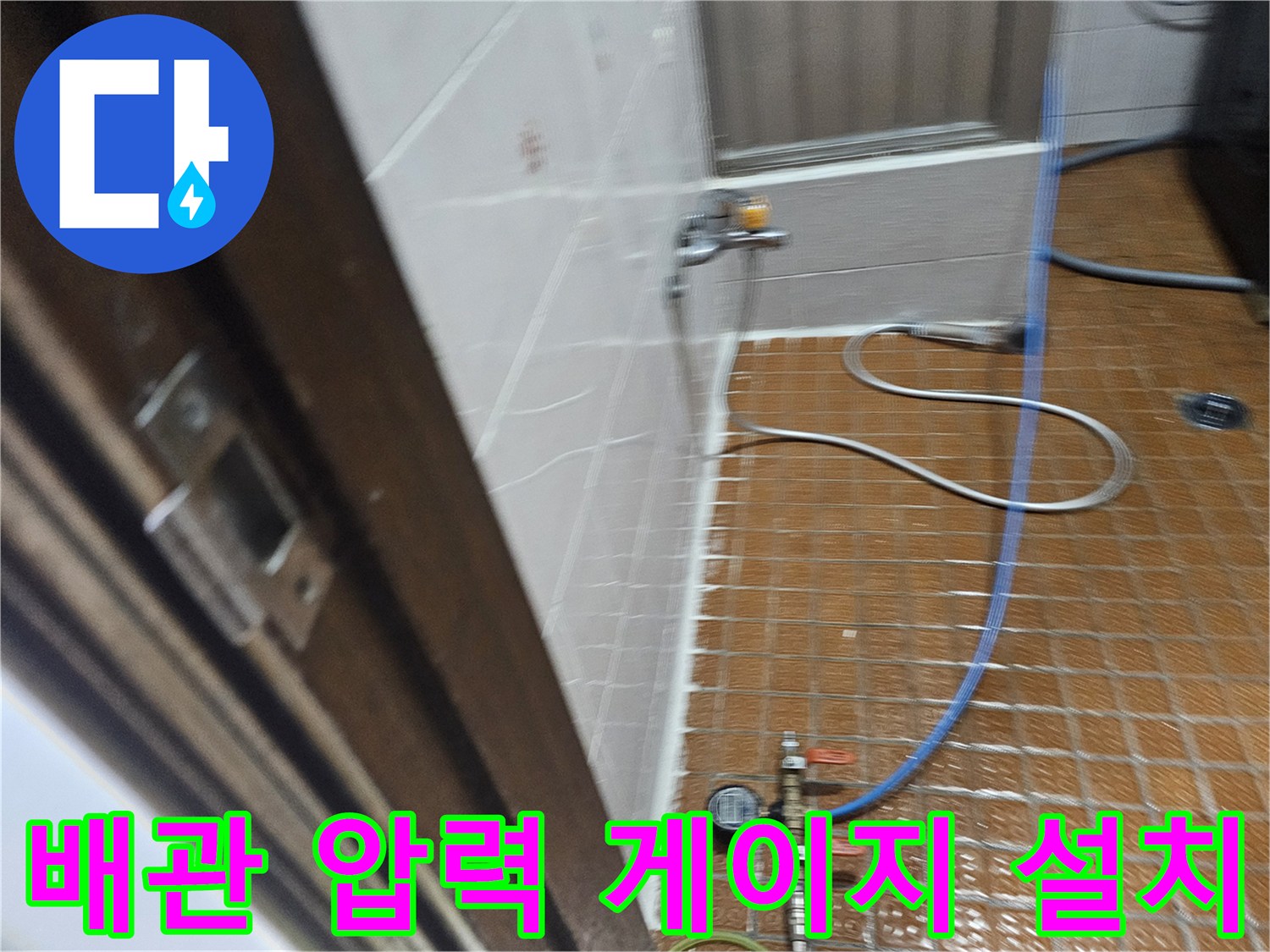 욕실 타일 바닥에 놓여 있는 배관 테스트용 장비 구성