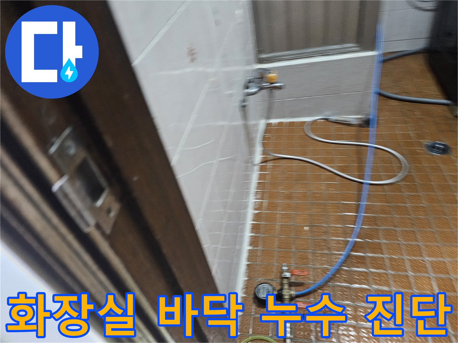 타일 바닥에 설치된 압력계와 연결된 파란색 호스