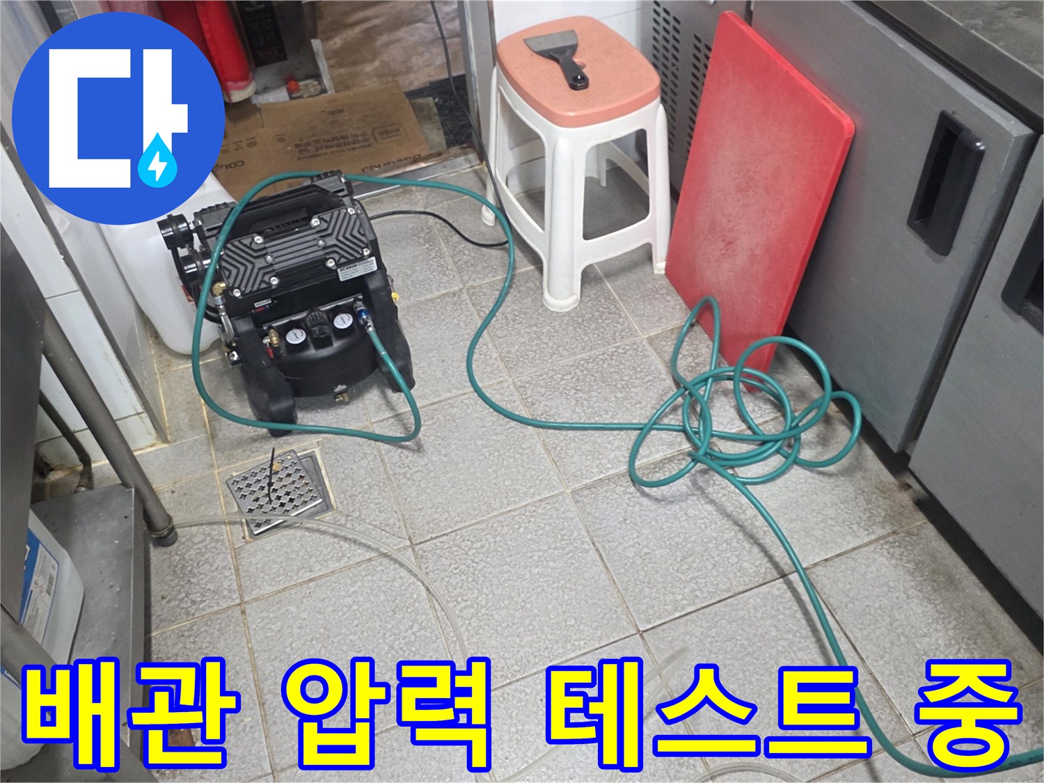 배관 누수 진단을 위해 디지털 게이지를 연결한 주방 작업 현장