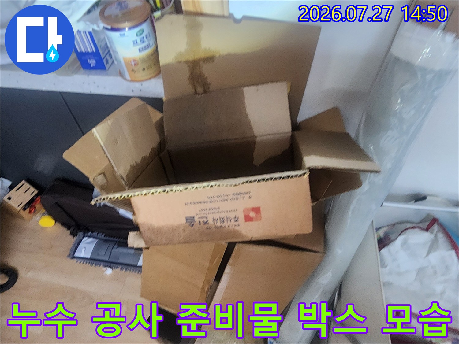 현장에서 사용될 보수 자재들이 담긴 열린 갈색 종이 상자