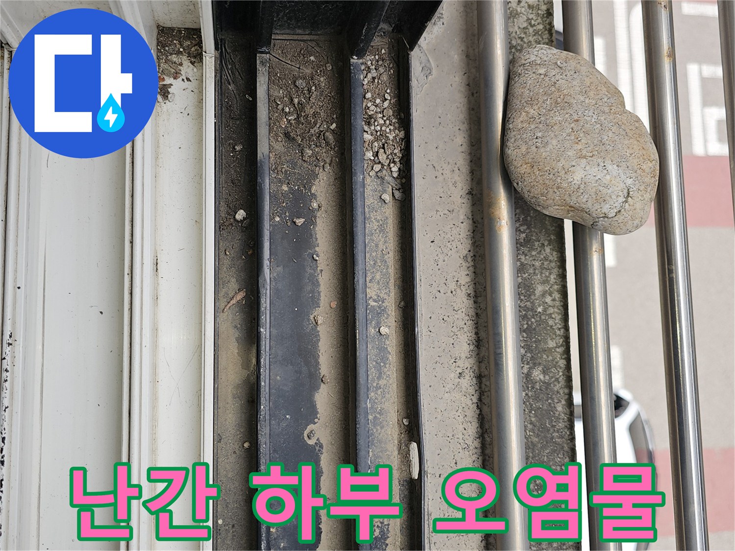 금속 난간 구조물 사이에 끼어 있는 돌과 흙