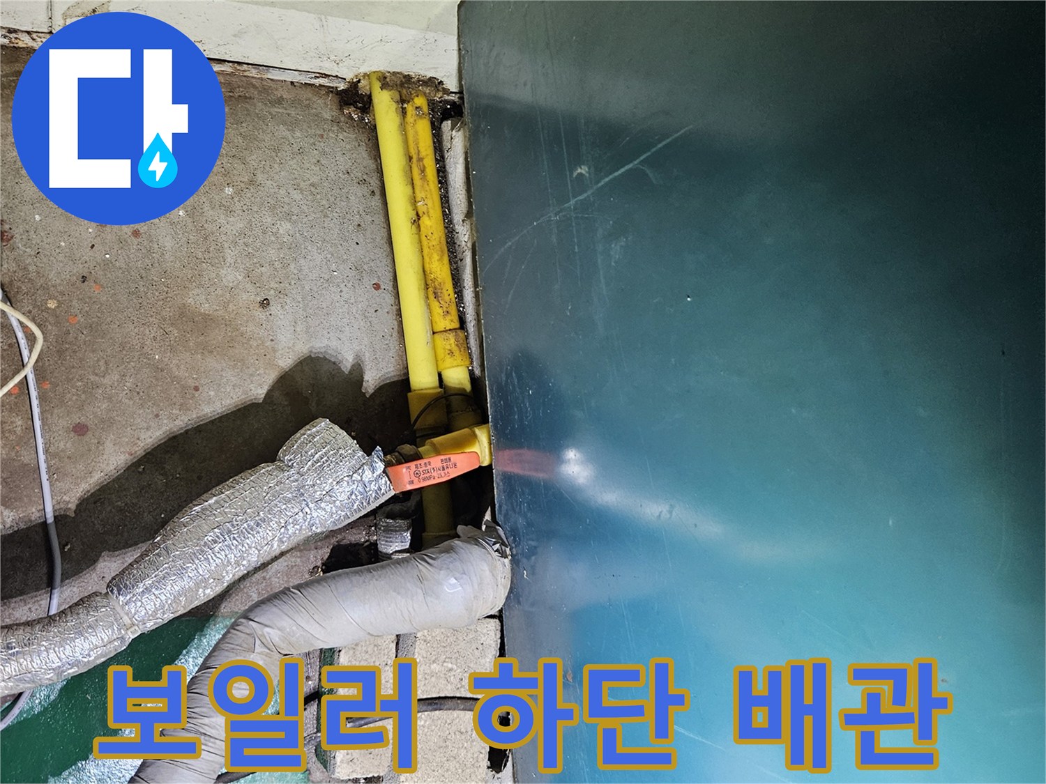 보일러 밑바닥-노란색 배관과 단열재가 노출된 모습