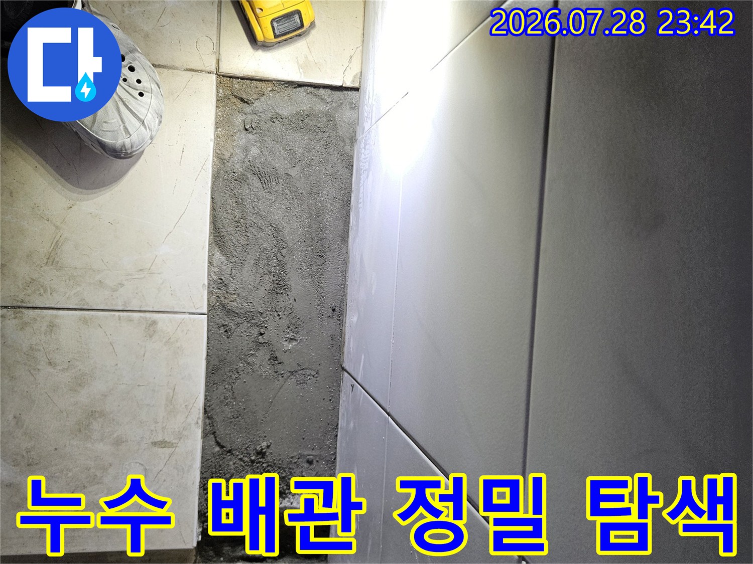 전동드릴과 보호구를 착용하고 누수가 발생한 벽면을 세심하게 파악하는 모습
