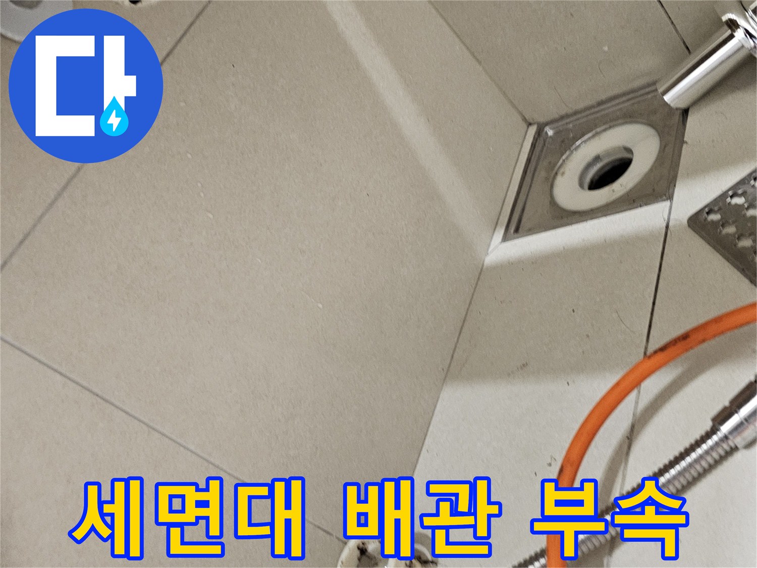 벽체에 설치된 세면대용 배수 연결구와 샤워기 호스 상세 사진