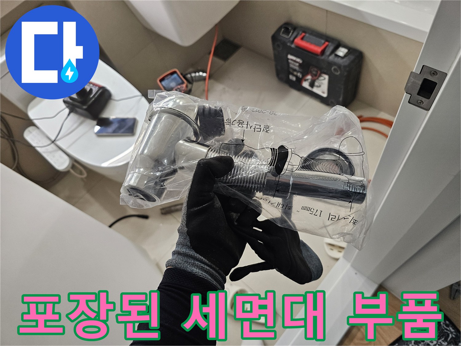 신규 배수 트랩과 연결 호스가 비닐에 포장되어 있는 모습입니다.