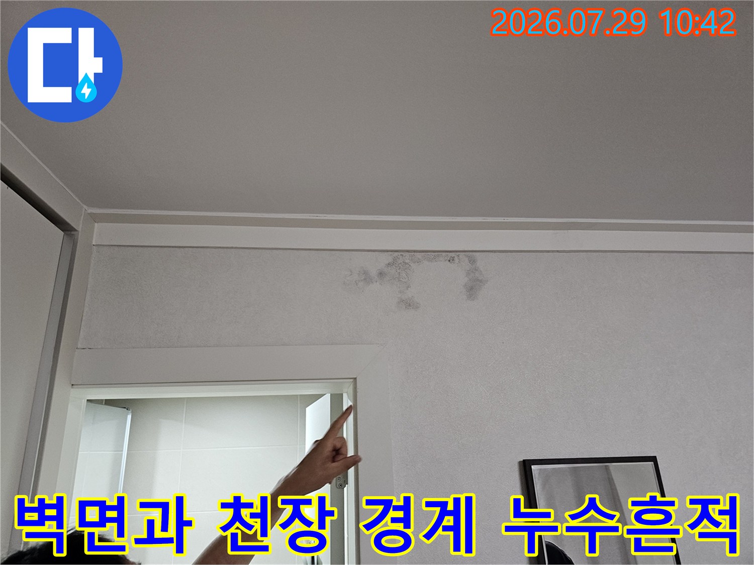 천장의 물자국을 가리키며 점검 중인 작업자의 모습