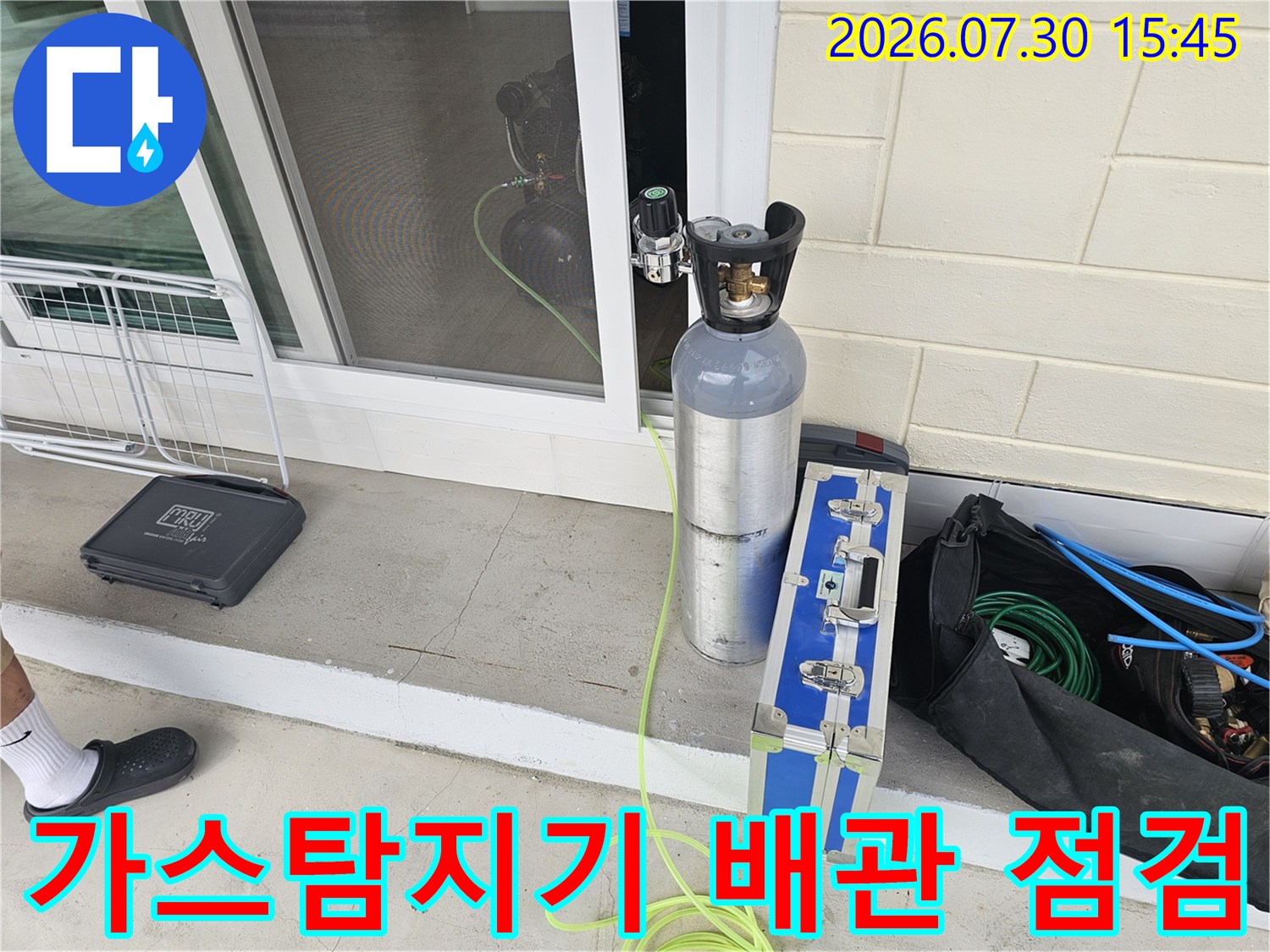 가스 탐지 장비와 노란색 호스를 연결하여 외벽 배관을 정밀하게 검사하는 모습
