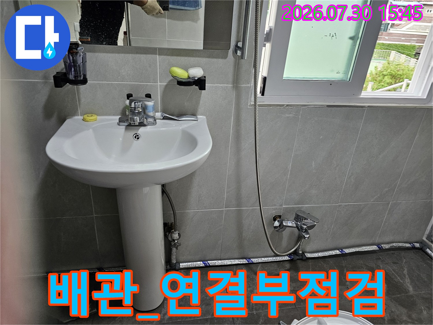 변기 하단 배관의 굴곡부와 연결 부품을 정밀하게 조사하는 현장 사진