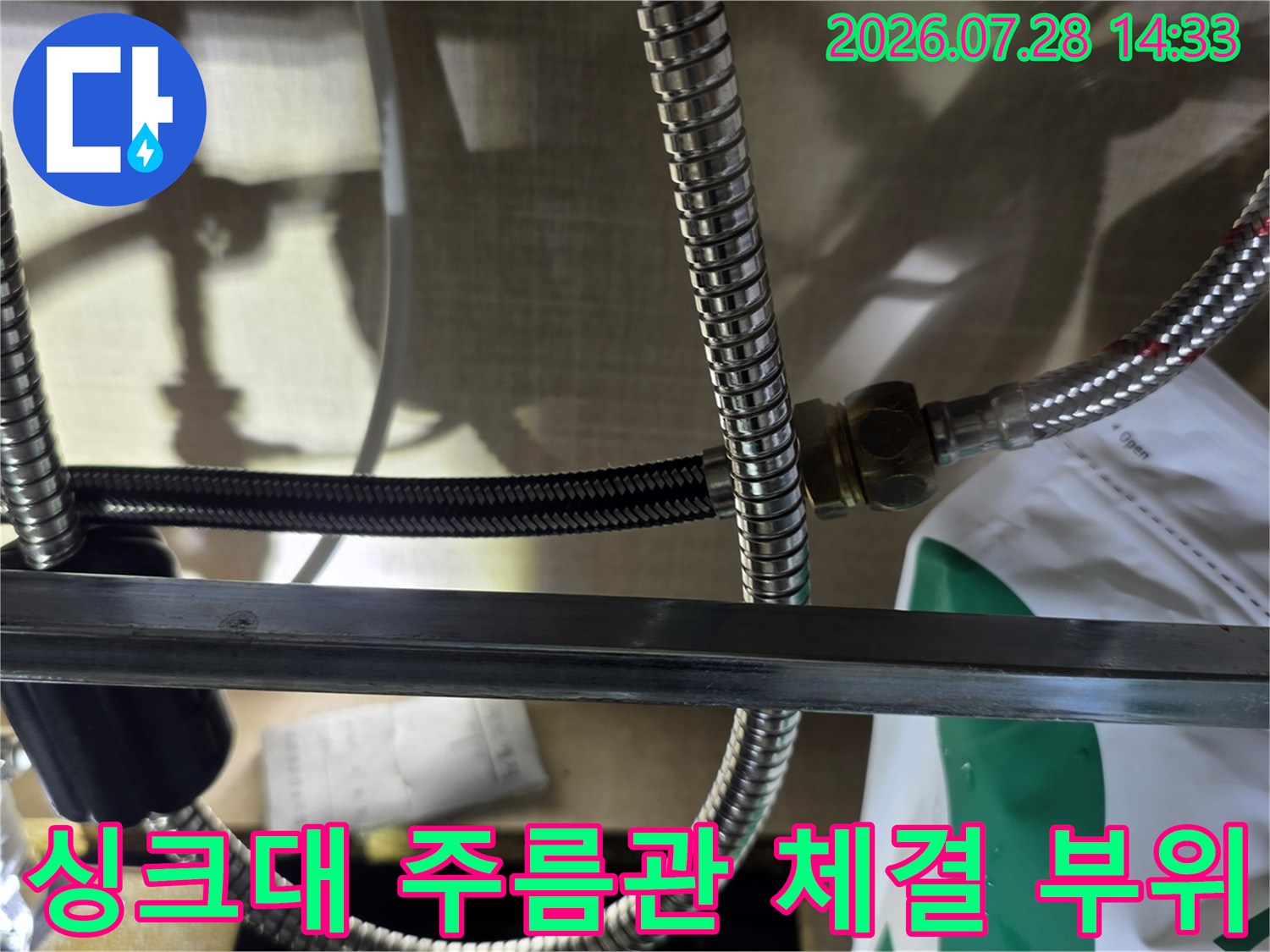 금속제 급수 호스의 연결 너트 부분에 물기가 맺혀 있고 패킹이 분리된 장면