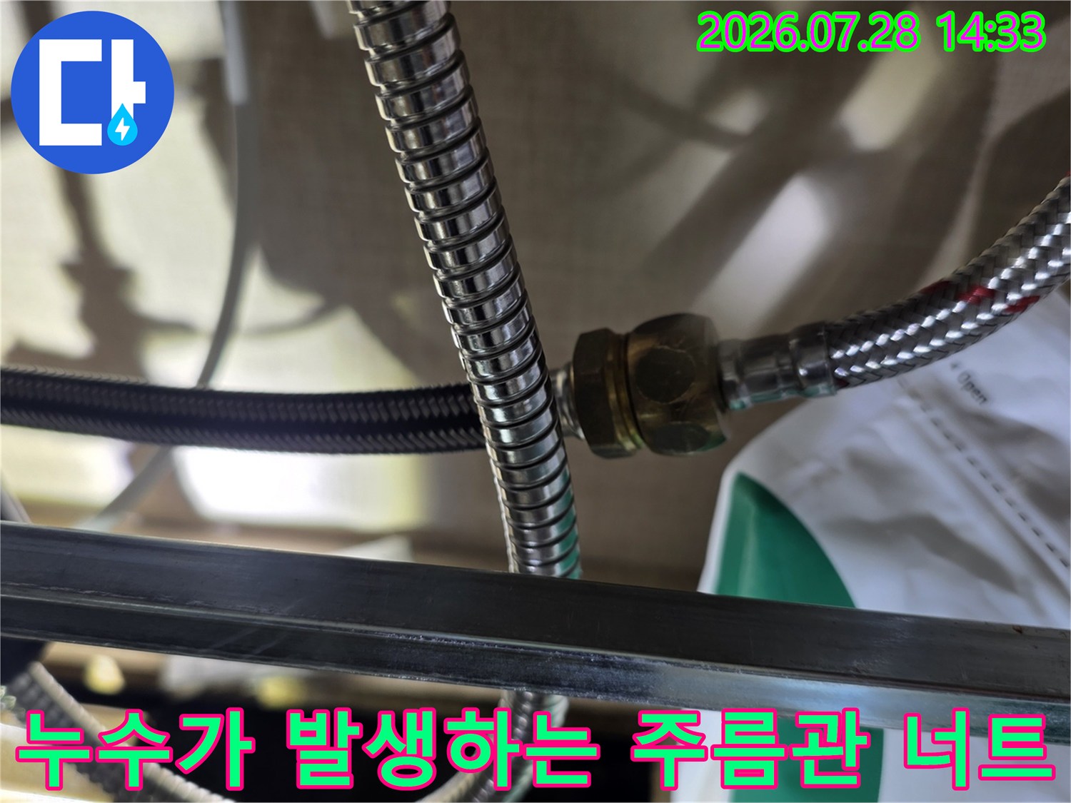 금속제 연결 너트 부위에 물기가 형성되어 누수가 진행 중인 배관 사진