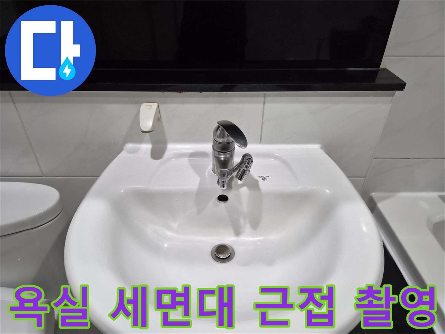 세면대 수전과 하단 배수구가 포함된 욕실 내부 모습입니다.