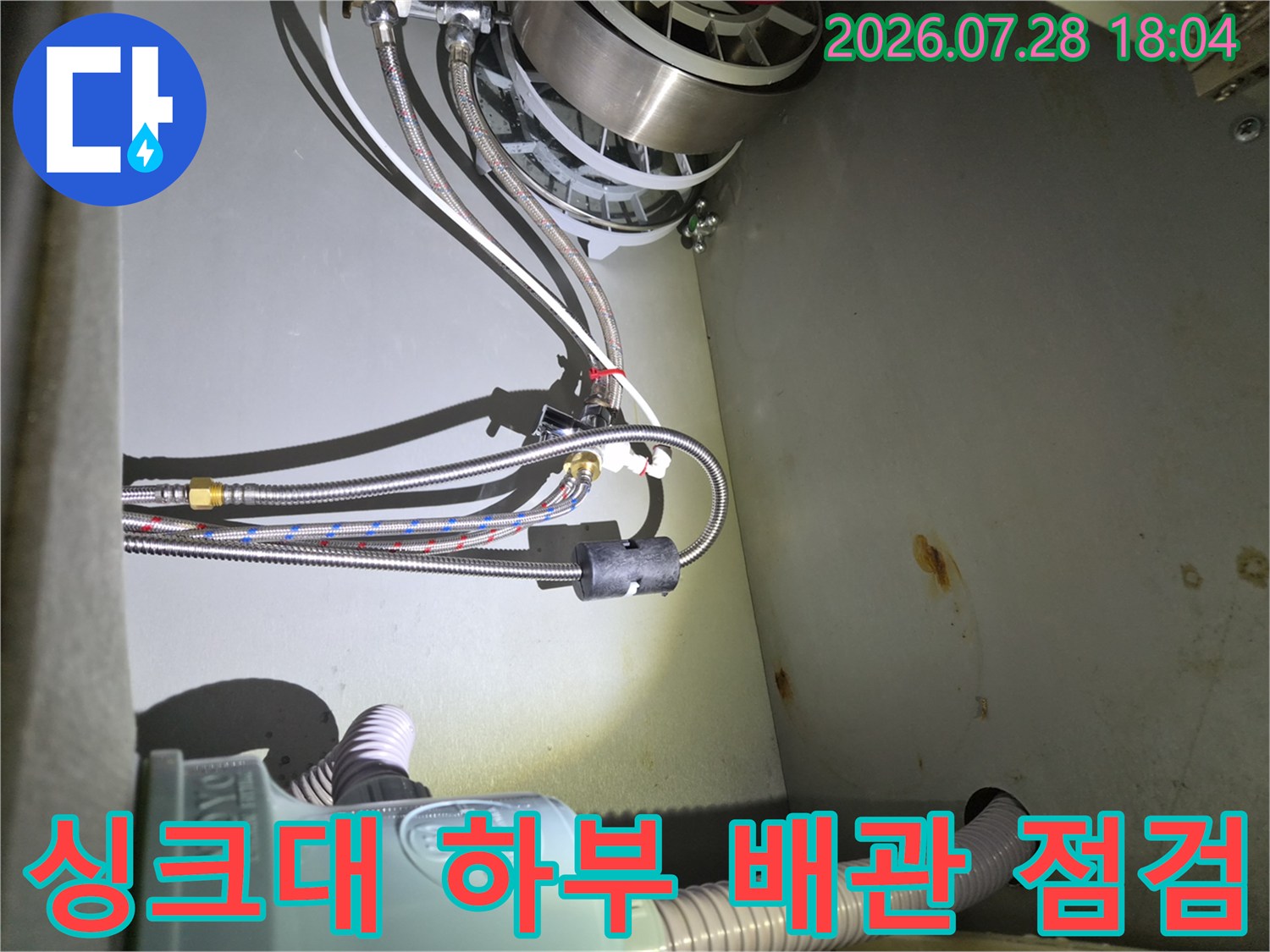 식기세척기 연결 부위의 배관 체결 상태를 점검하는 모습
