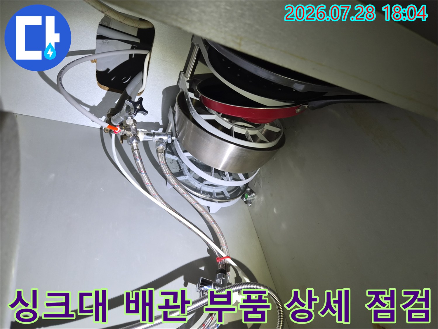 싱크대 하부 공간 내부에 위치한 식기세척기 관련 배관 구조를 파악하는 모습