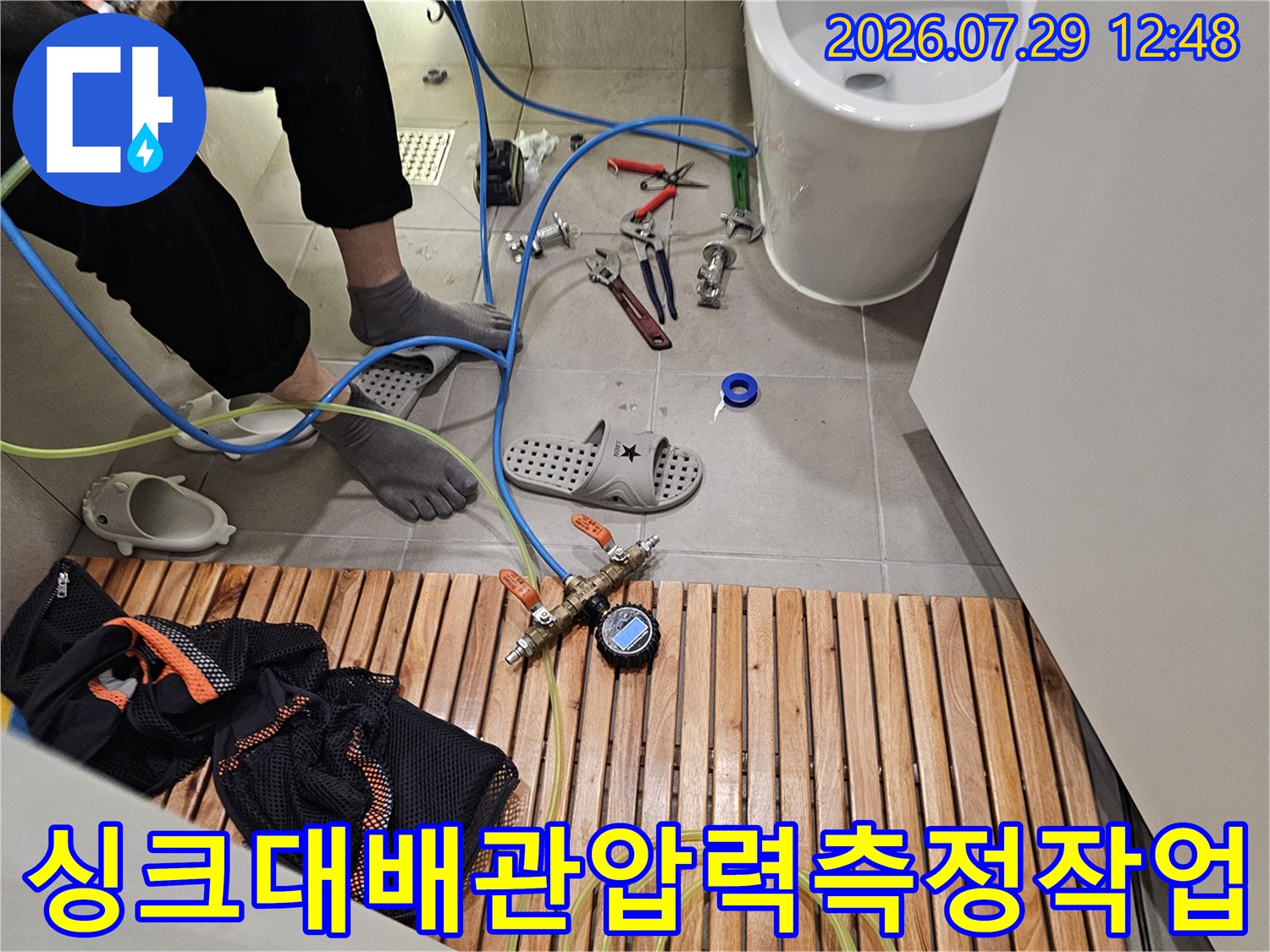 배관 세척용 호스와 압력계가 연결된 배수구 점검 장면