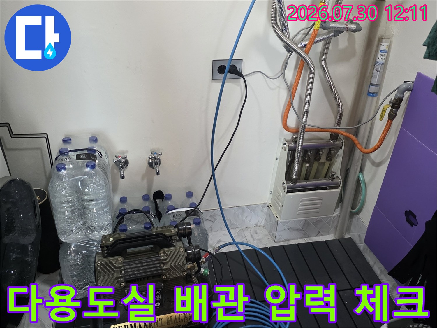 공압 테스트를 위해 세탁실 배관에 연결된 다양한 호스와 장비들