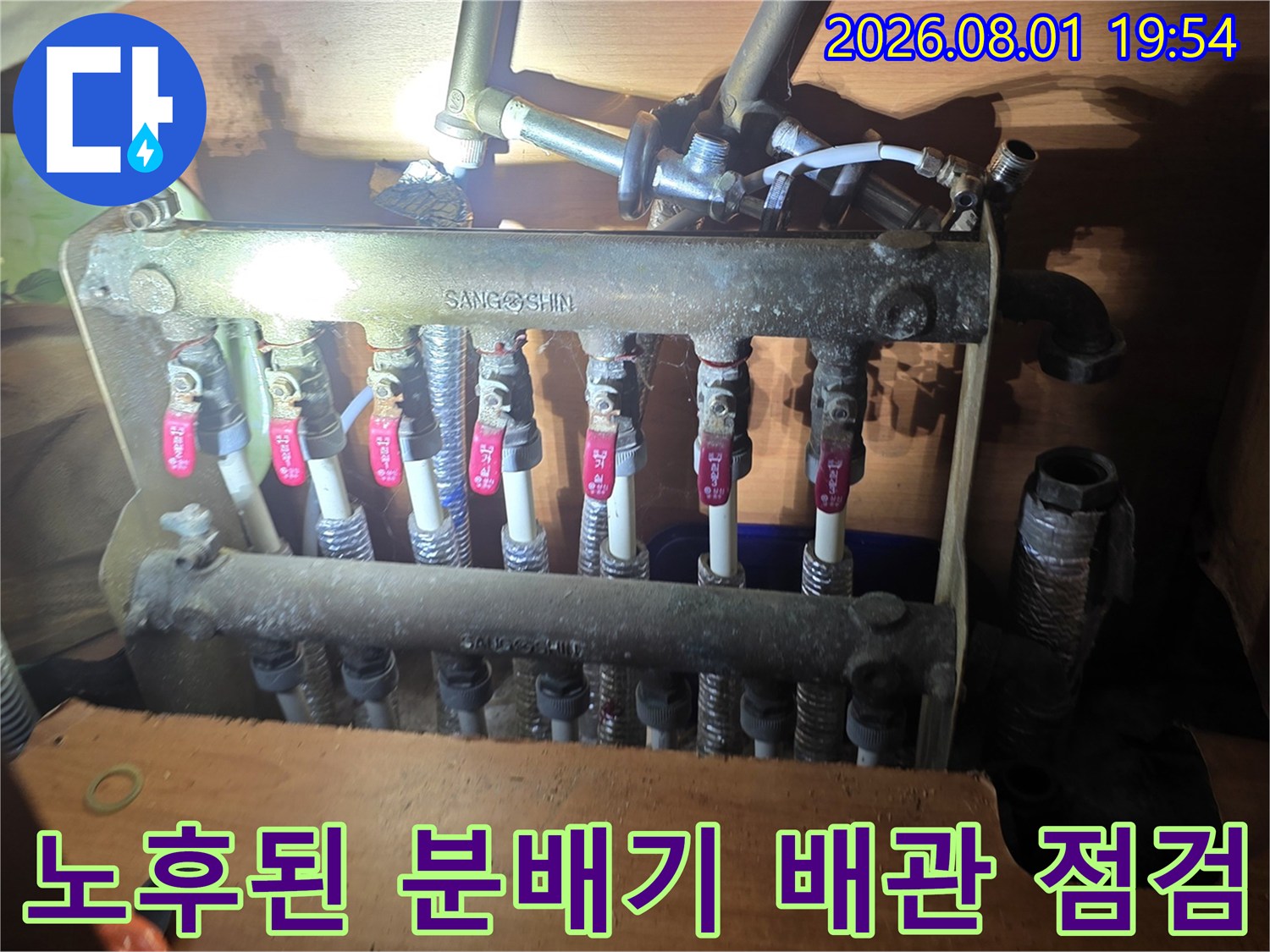 상단에 노출된 여러 개의 밸브가 달린 금속 재질의 분배기 배관 시스템