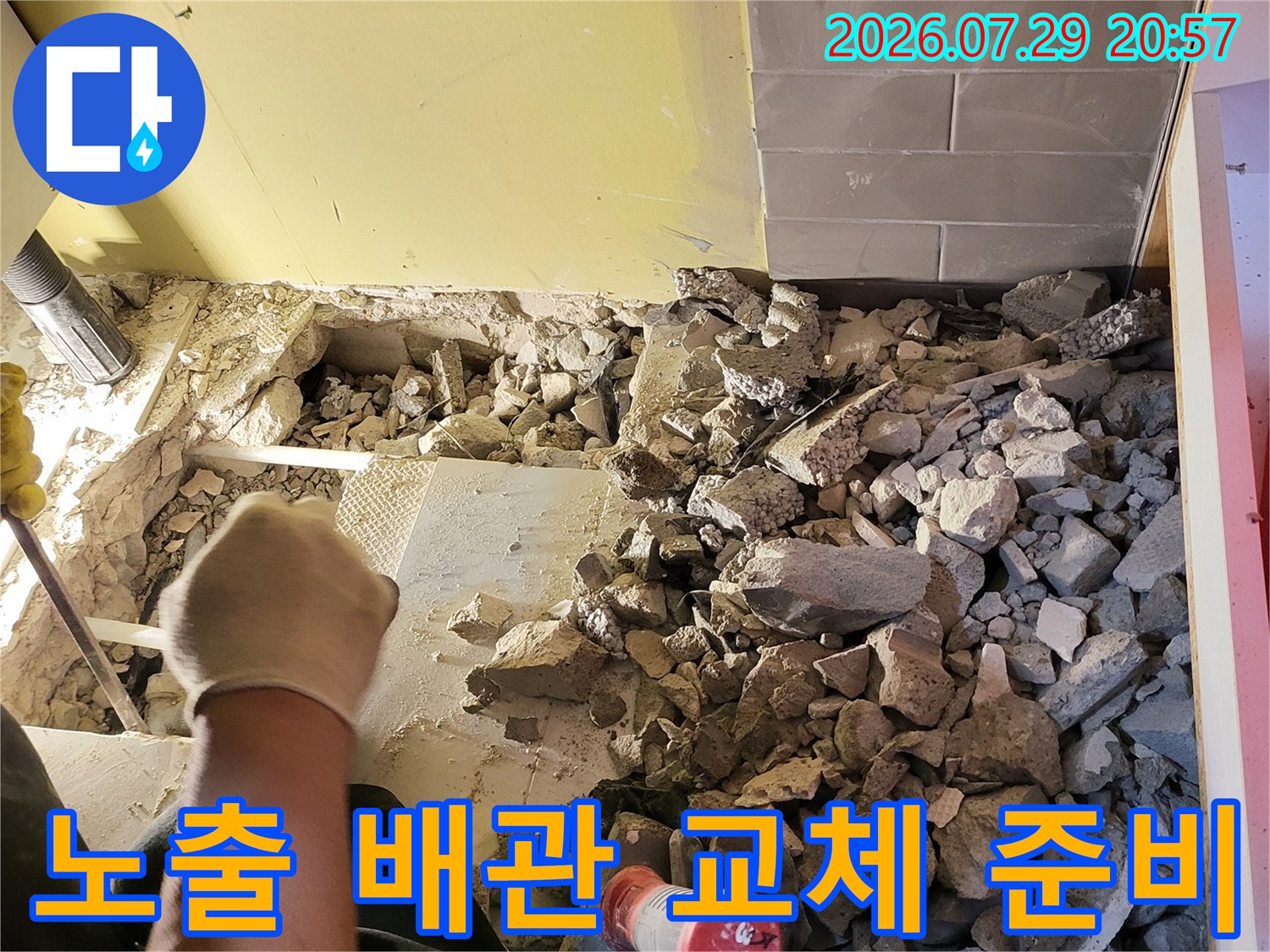 돌 파편들과 섞여 있는 노출된 온수 파이프 수선 부위