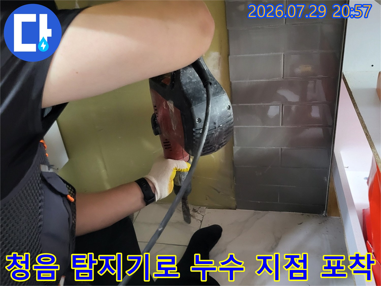 싱크대 아래쪽에서 청음 장비를 사용하여 배관 누수 위치를 정밀하게 추적하는 모습