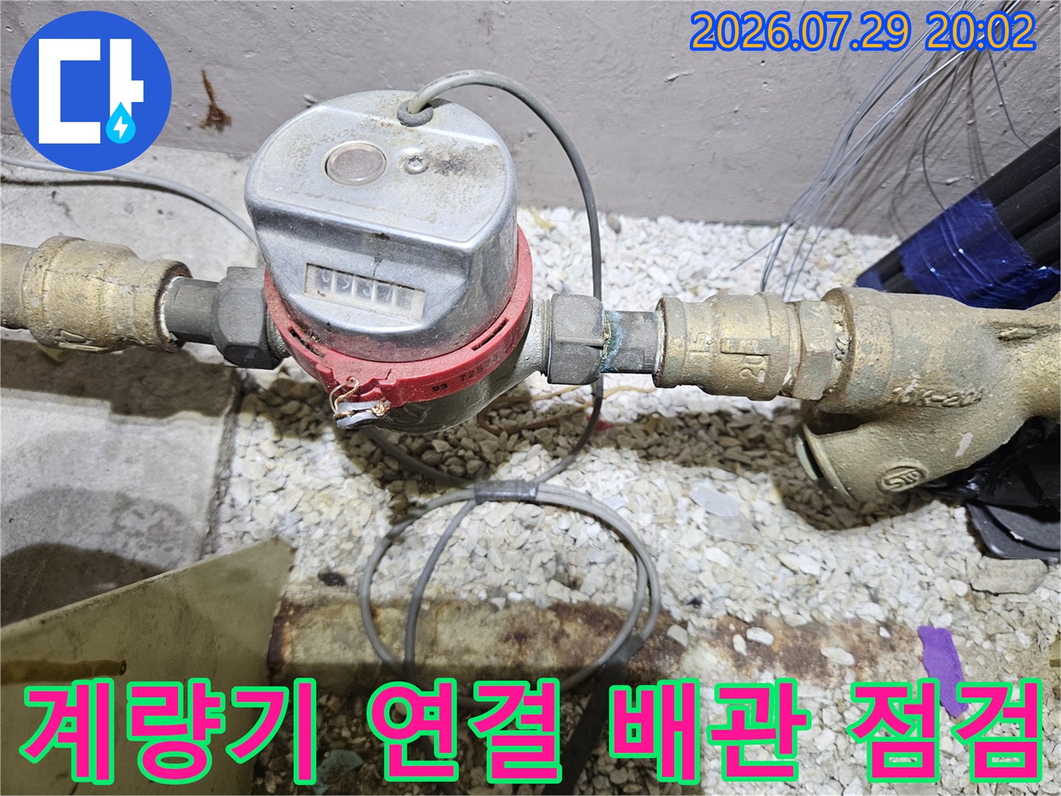 세면대 하단에 위치한 수도 계량기와 배관 연결 부위의 정밀 진찰