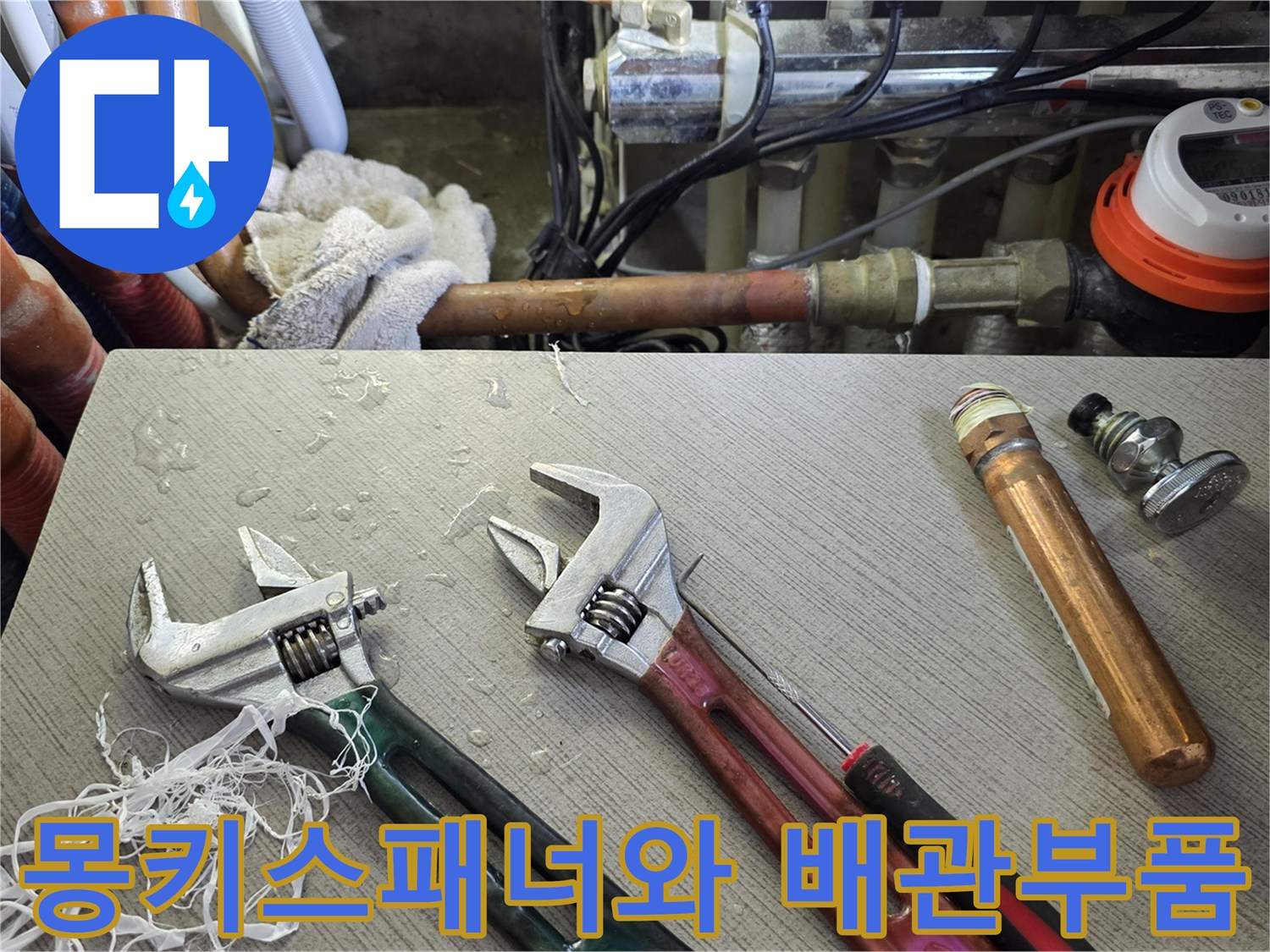 누수 수선 작업을 위해 준비된 몽키스패너와 교체용 배관 부속