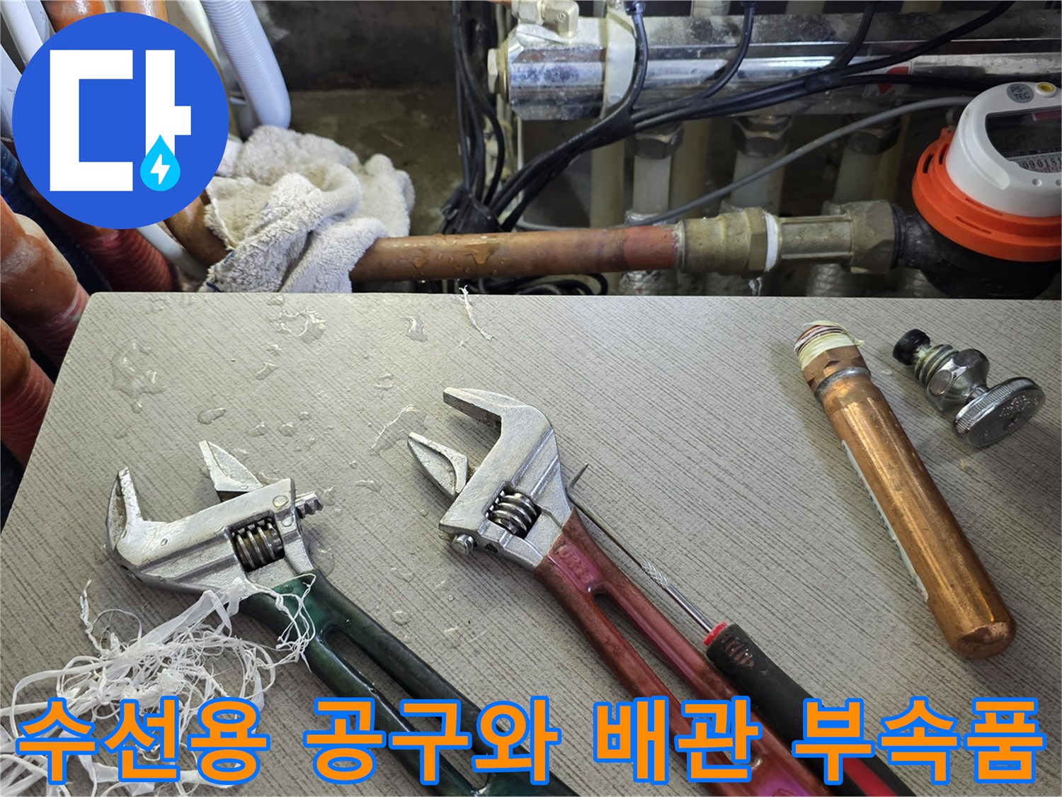배관 연결부 수리를 위해 준비된 몽키스패너와 금속 파이프 자재