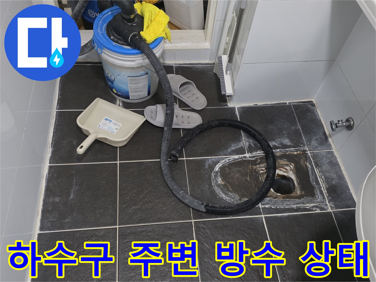 배수구 근처 타일이 제거되어 내부 배관이 노출된 사진