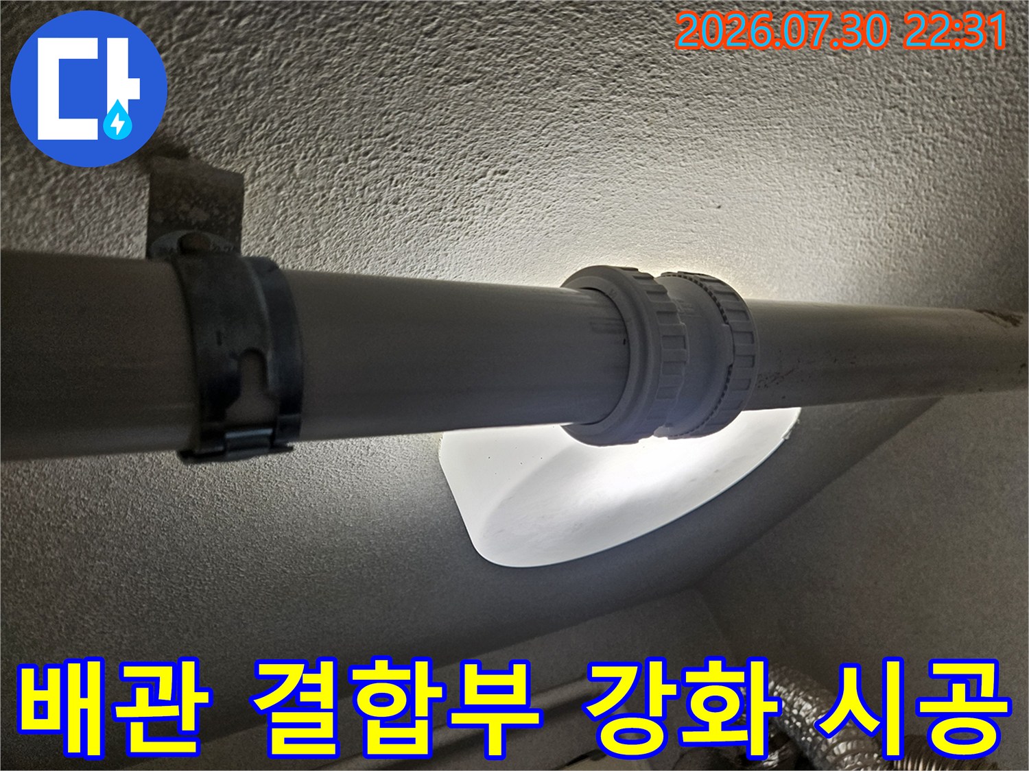 커플링과 밴드를 활용하여 배수 파이프 연결 부위를 견고하게 고정한 모습