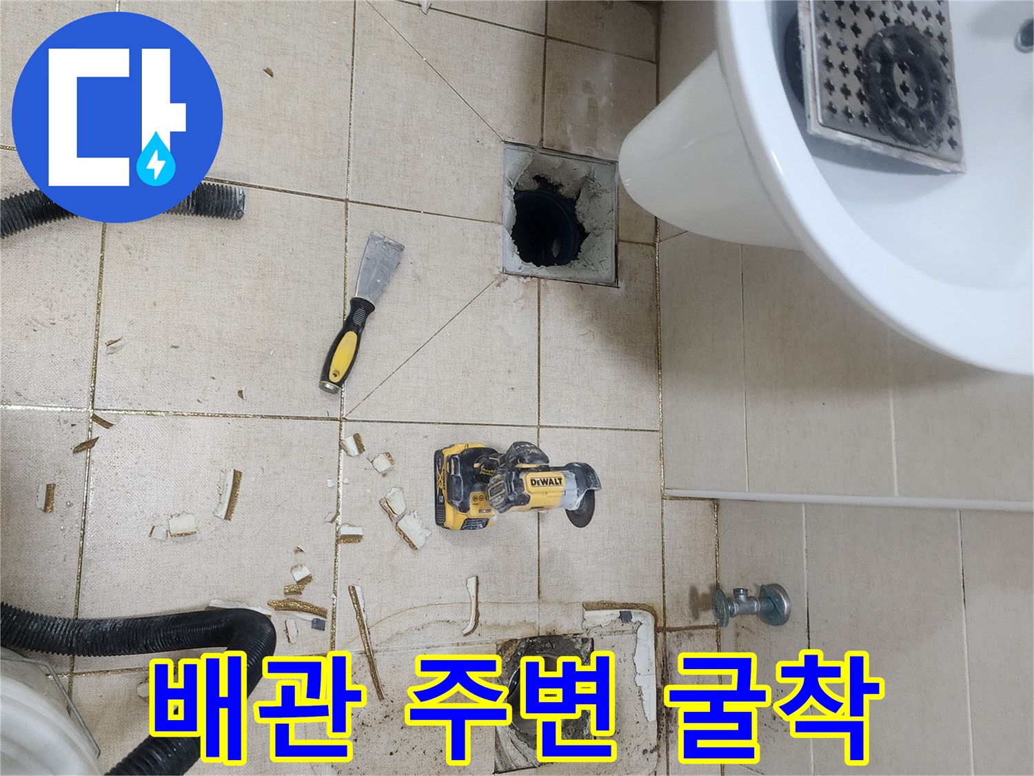 타일을 제거하고 드러난 하수구 배관과 공구들