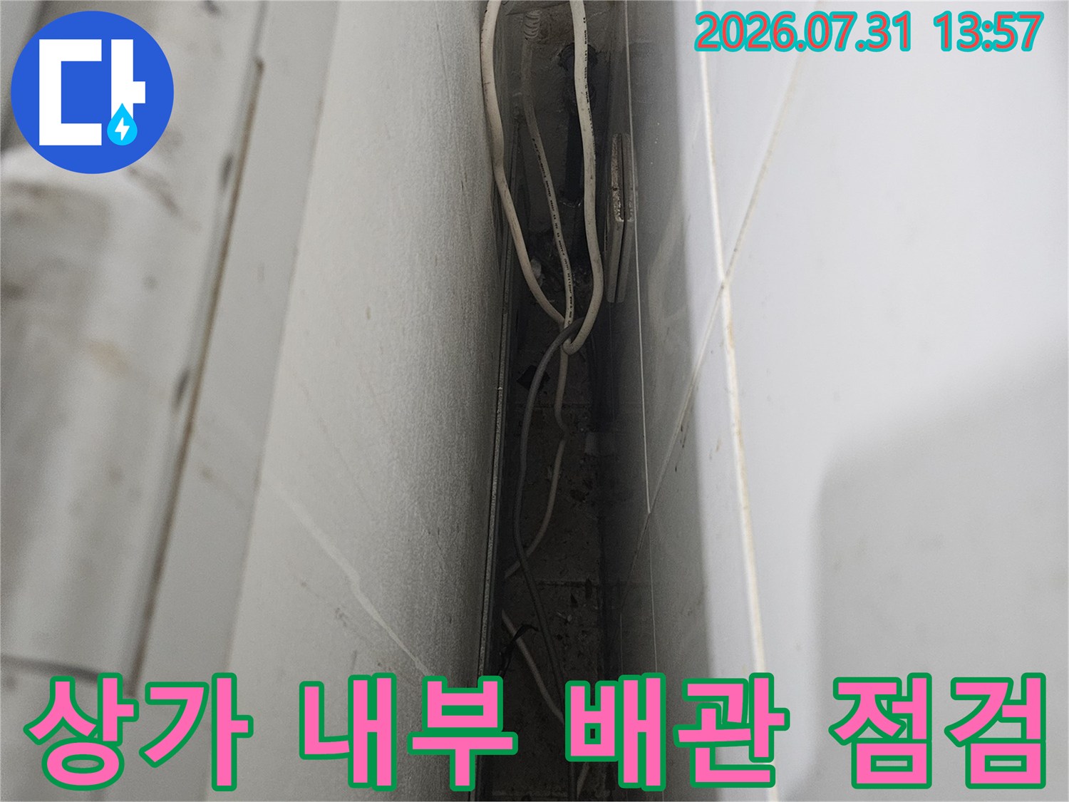 상가 내부에 노출된 하얀색 수도 배관과 연결 부위를 점검하는 모습