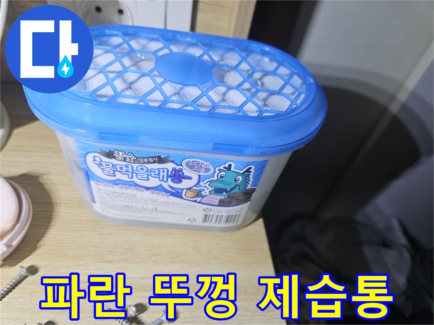 장롱 하부 습기 제거를 위해 놓여 있는 파란색 뚜껑의 용기