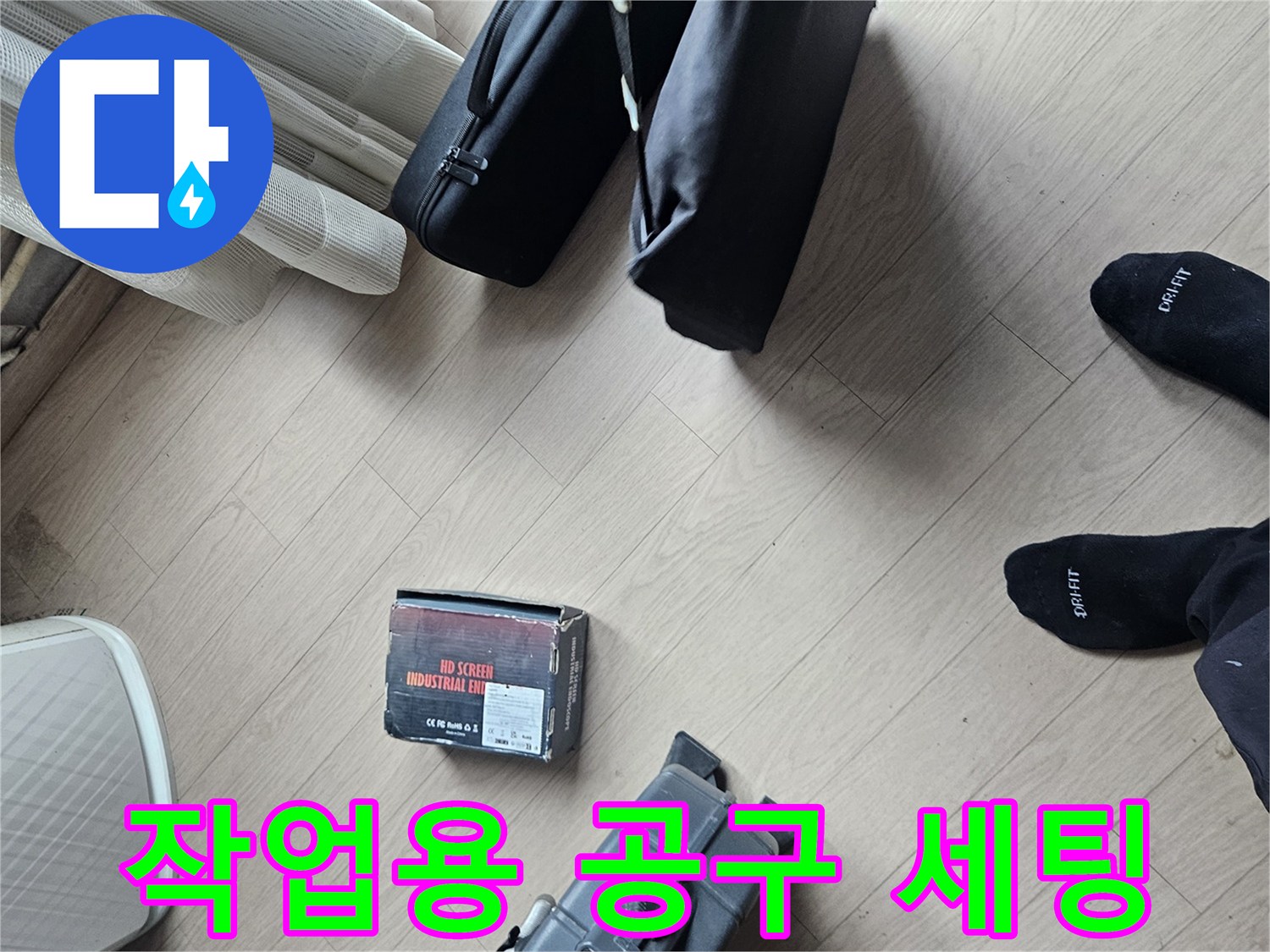 바닥에 놓인 충전식 드릴과 수리용 소모품 및 장비들