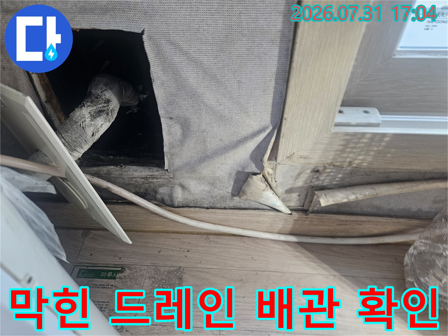벽면을 뚫고 나온 에어컨 배출 배관의 구조를 점검하는 사진