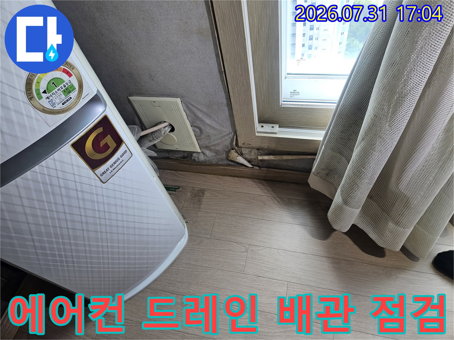 에어컨 본체 하단과 연결된 드레인 배출 배관을 정밀하게 점검하는 모습