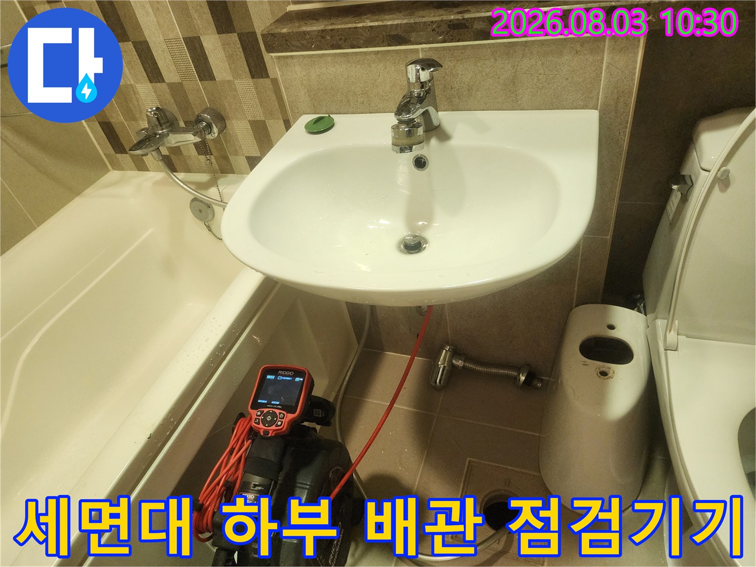 특수 장비를 사용하여 세면대 아래 배출구 라인을 정밀하게 검사하는 모습