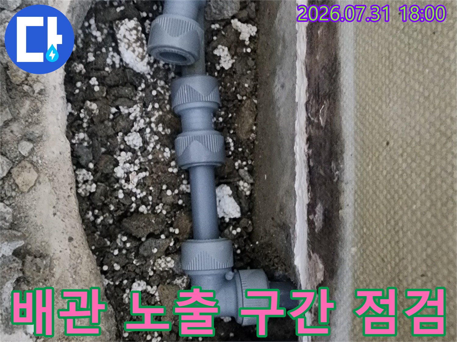 흙 속에 묻혀있던 회색 파이프와 연결 부품들이 드러난 모습