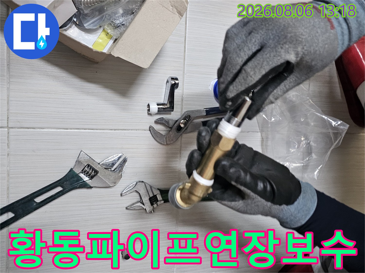 작업자가 장갑을 끼고 몽키스패너로 황동 배관과 연결 부품을 고정하는 모습
