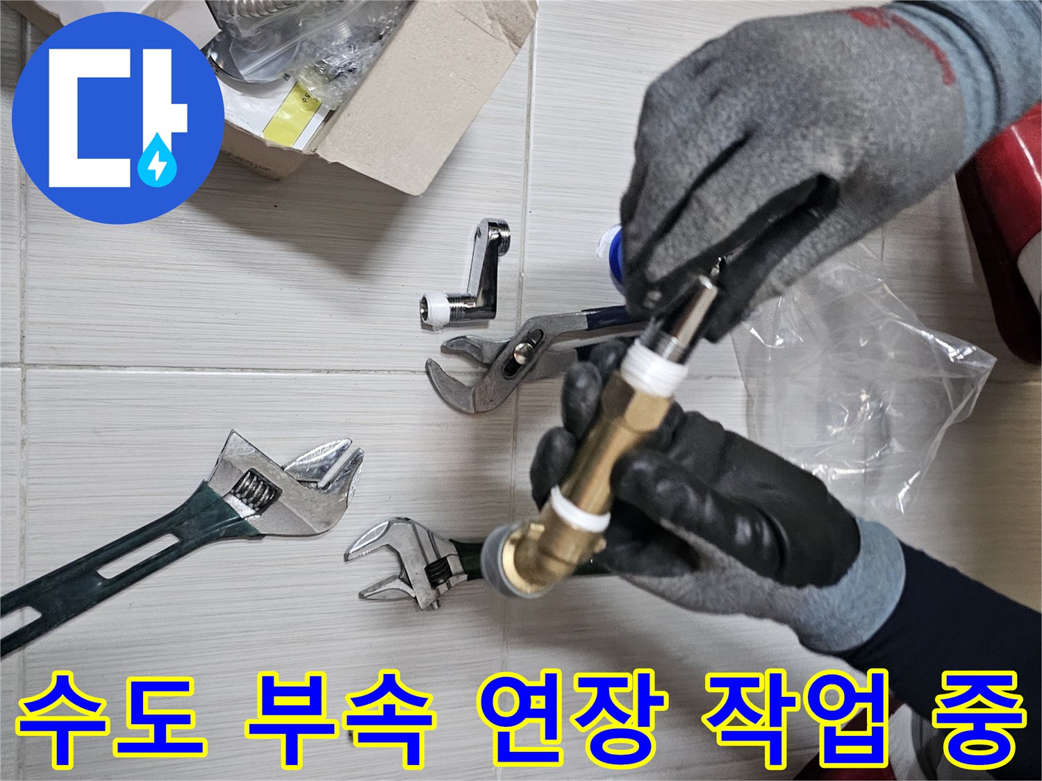 장갑을 낀 손으로 금색 수전 부속을 들고 있는 모습