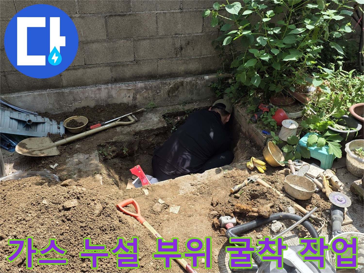 현장에 놓인 청소기와 삽-가스 배관 노출을 위한 굴착 중