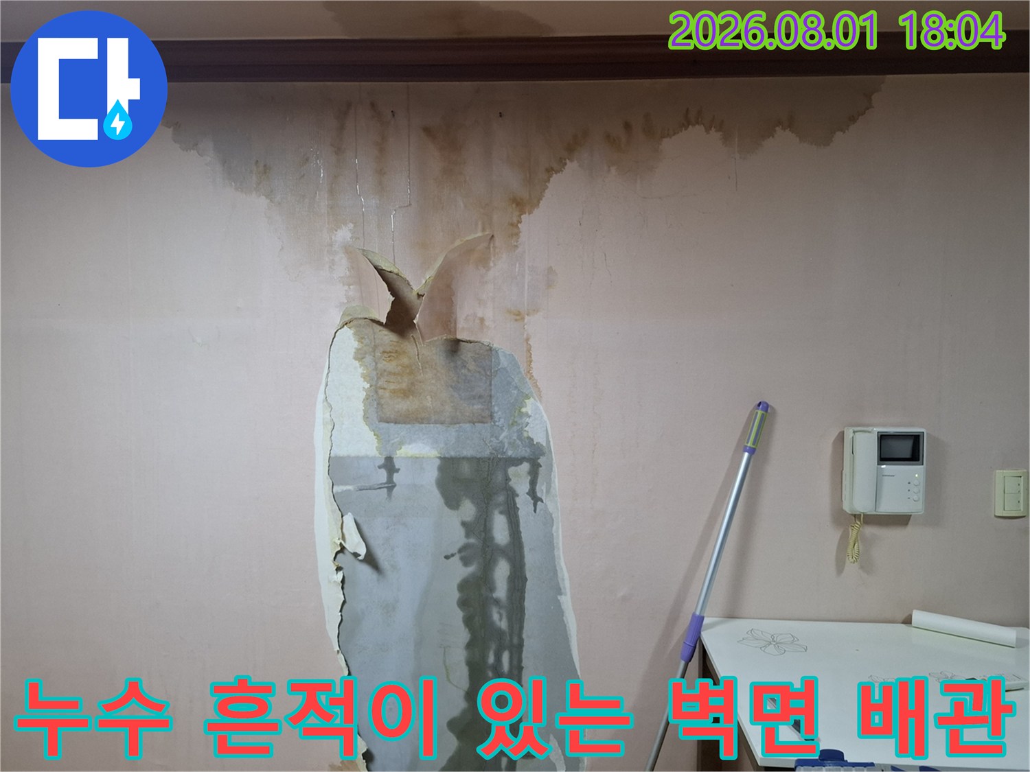 벽을 뚫어 노출시킨 누수 지점과 주변의 습기 얼룩