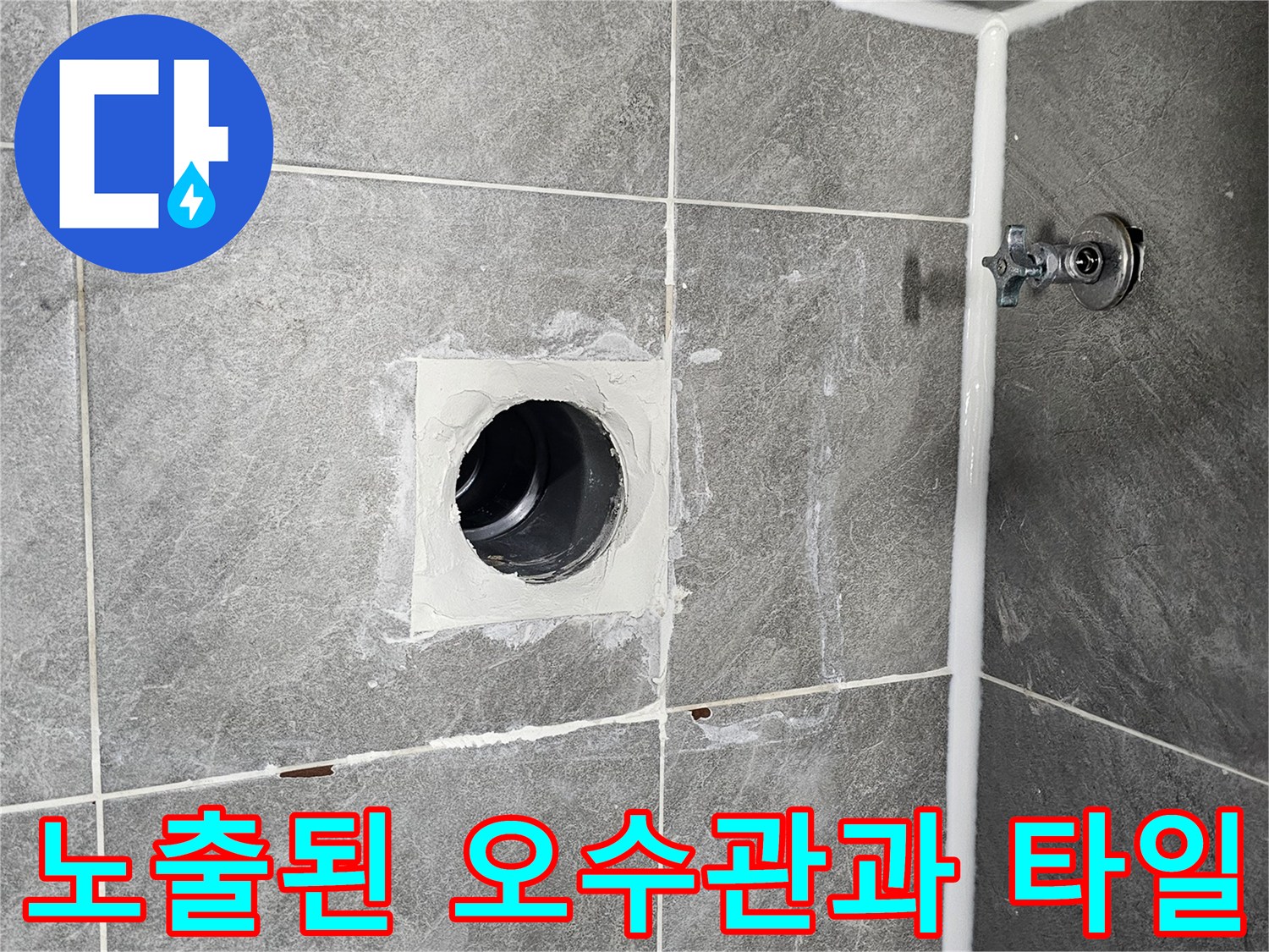 타일 바닥에 노출된 오수관 입구와 주변의 거친 마감면