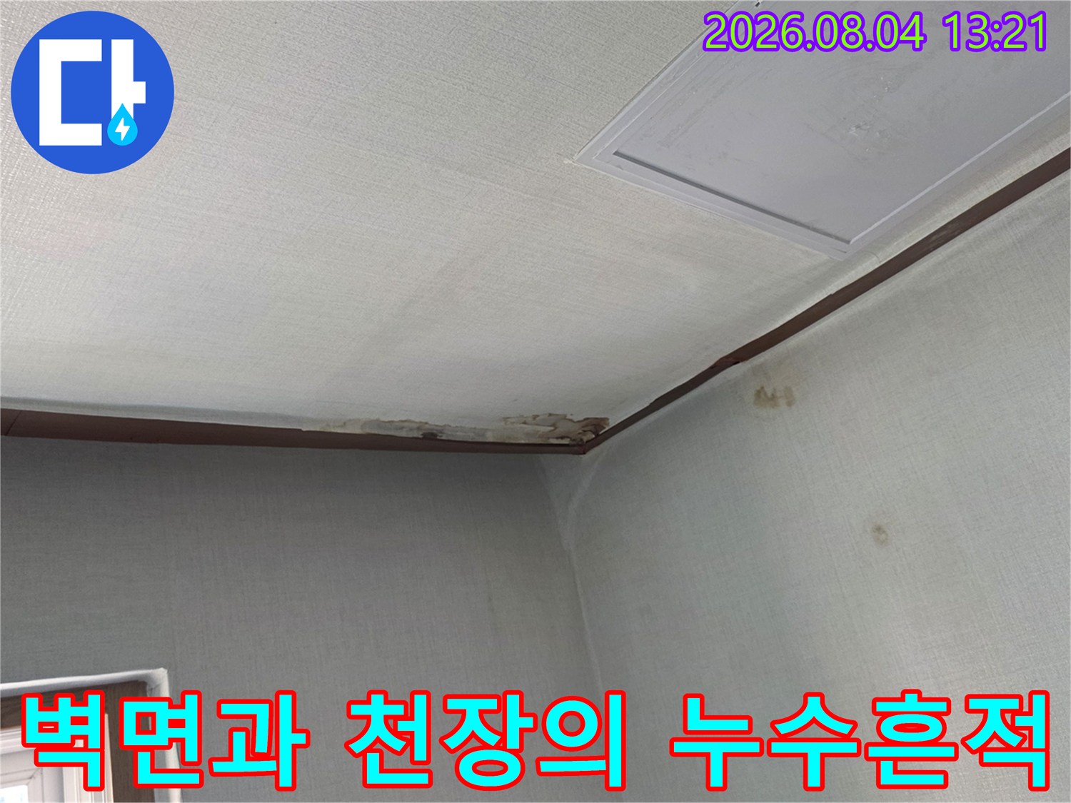 천장 모서리 부분의 변색된 벽지와 누수로 인한 오염 부위
