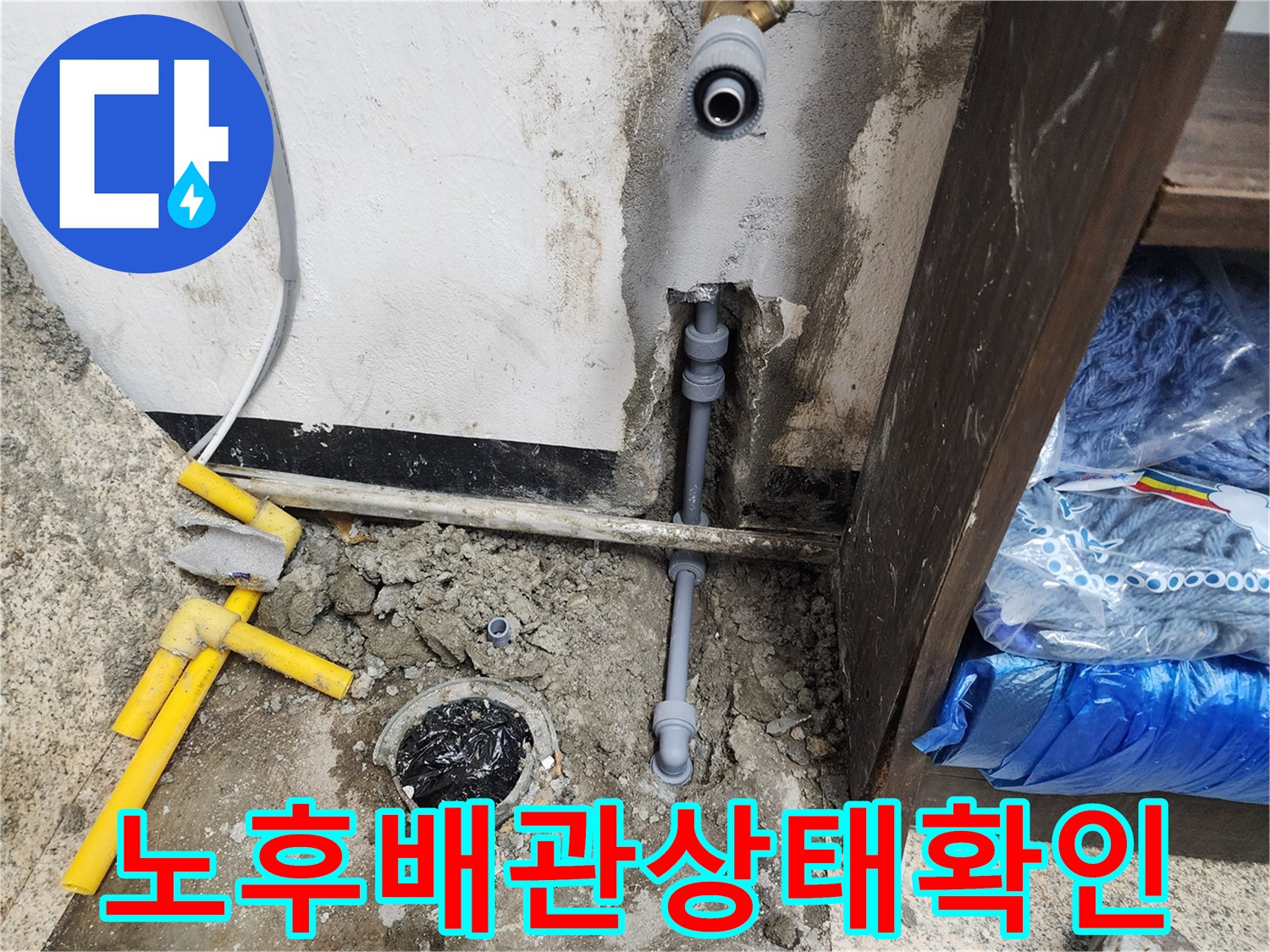 바닥에 노출된 회색 배관과 물기가 남아 있는 작업 부위