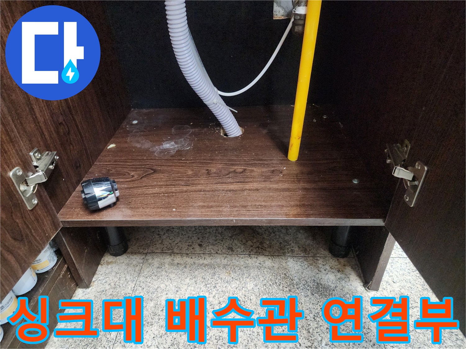 싱크대-내부-벽면-관통-배관과-회색-주름호스