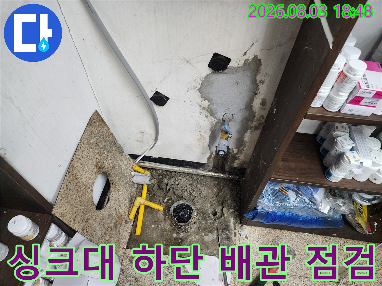 싱크대 밑 노란색 관과 젖은 자국을 촬영한 누수 진단 현장 사진