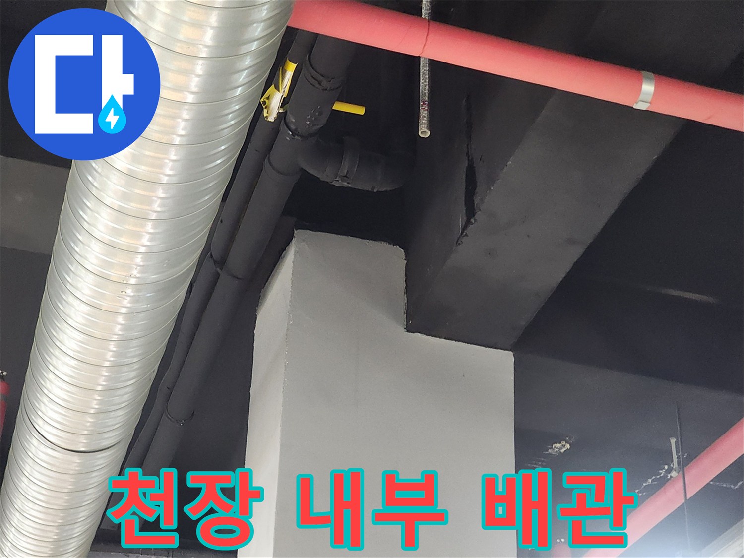 천장 구조물 사이 은색 덕트와 붉은 급수 관로