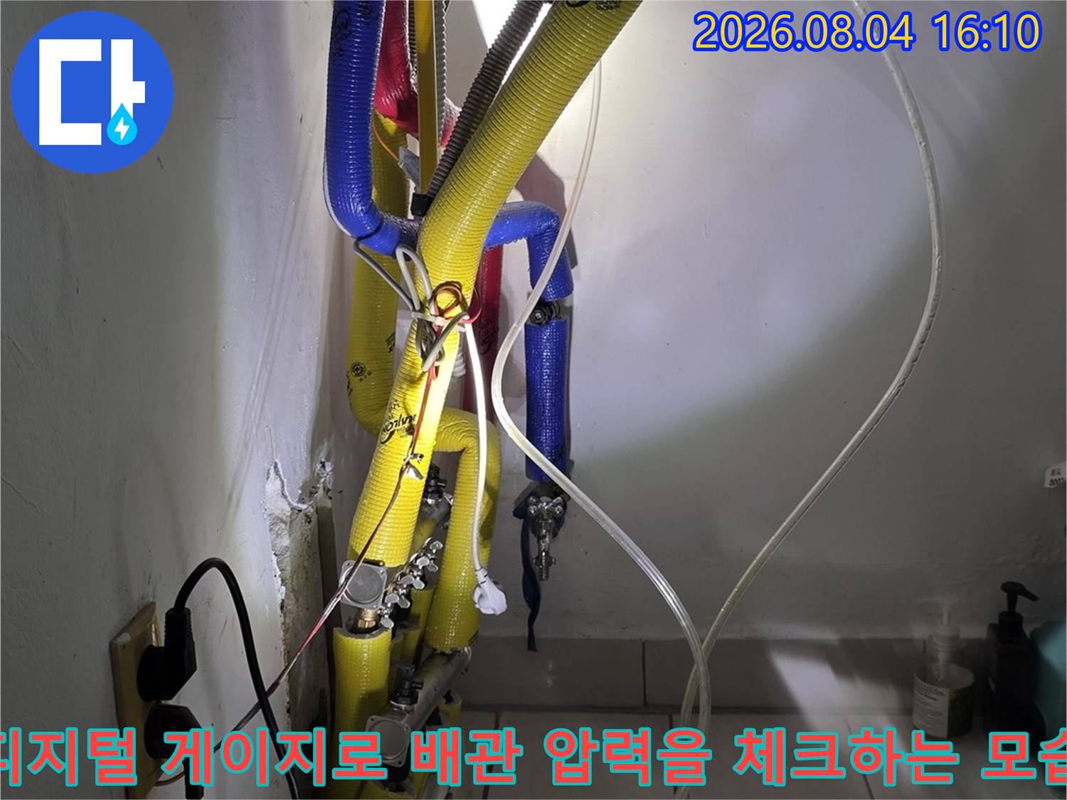 다양한 색상의 배관과 연결된 검사 장비의 공압 측정 장면