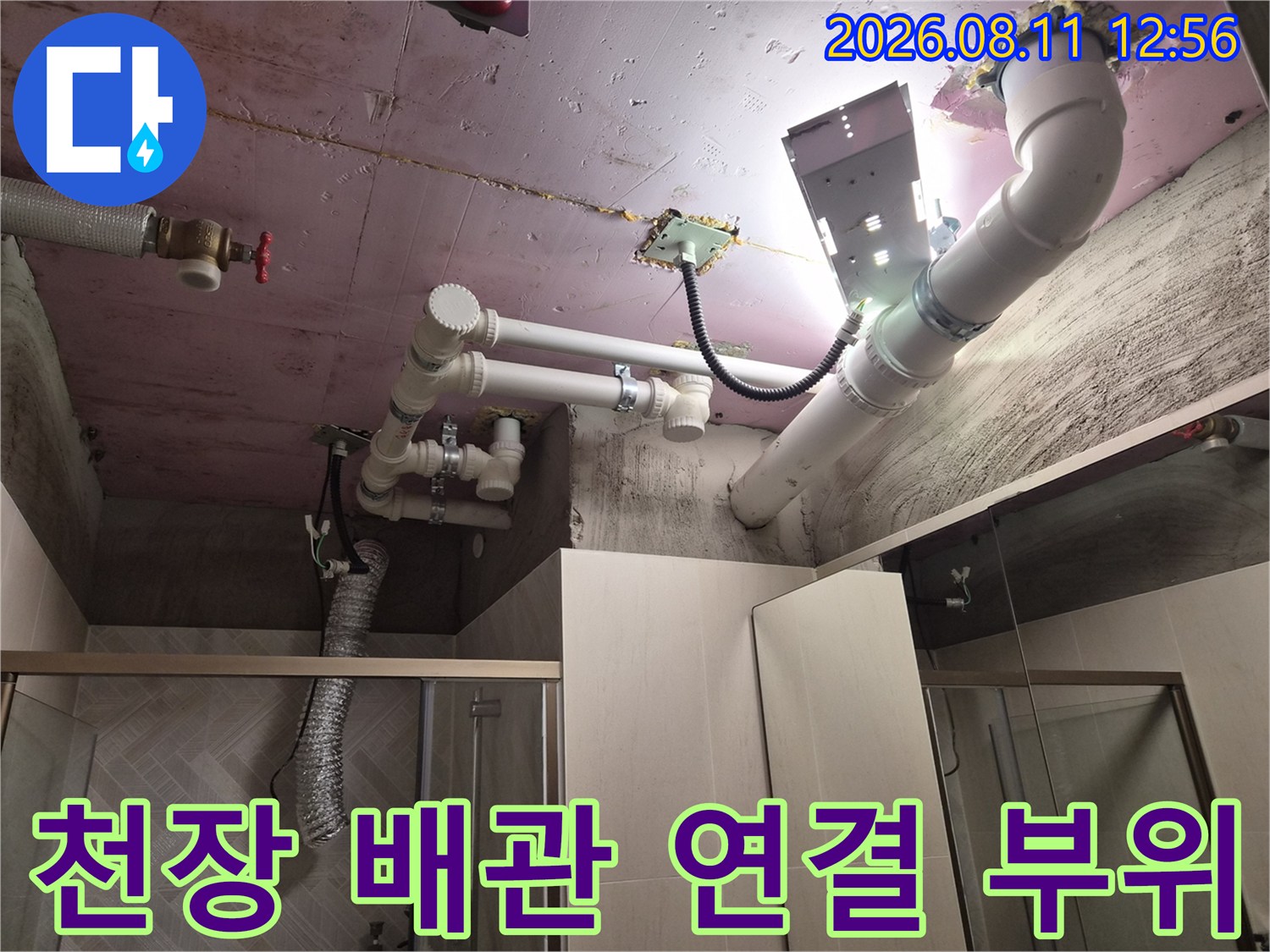 욕실 천장 슬라브에 설치된 굵은 배관과 연결 소켓의 누수 점검 상황